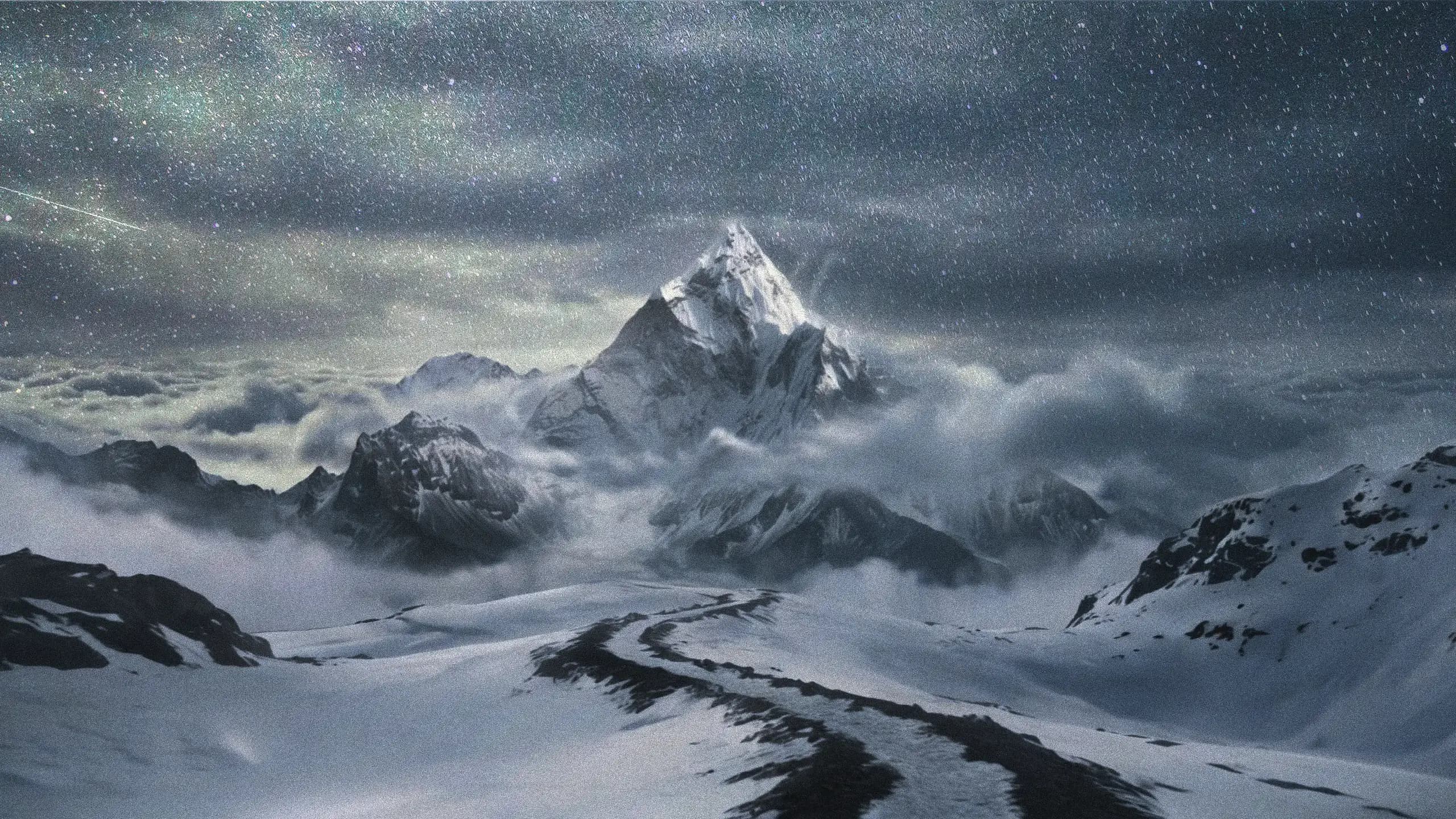 Snow-capped mountains rising above the clouds